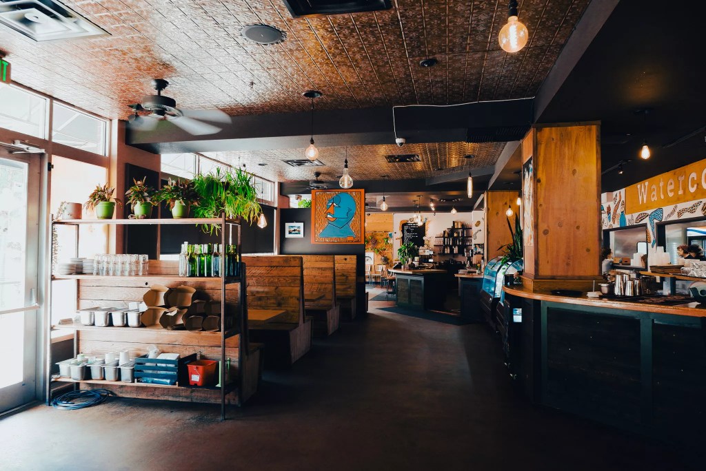 The interior of Watercourse Foods, featuring wood fixtures and local art