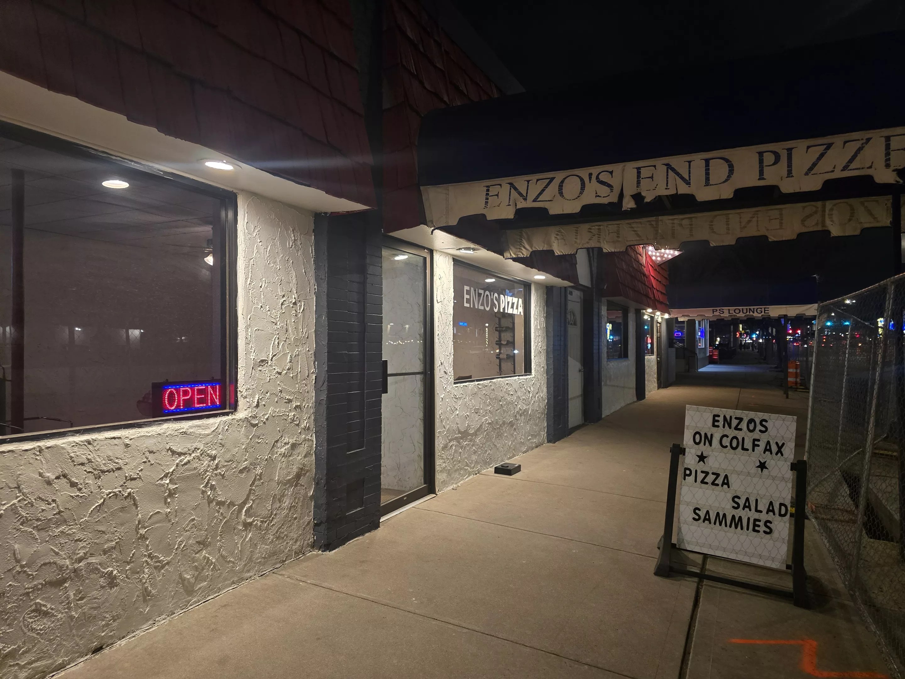Enzo's on Colfax storefront next to fence from the BRT construction.