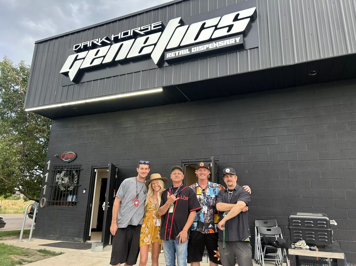 Dark Horse Genetics staff members backdropped by the dispensary's black-painted exterior