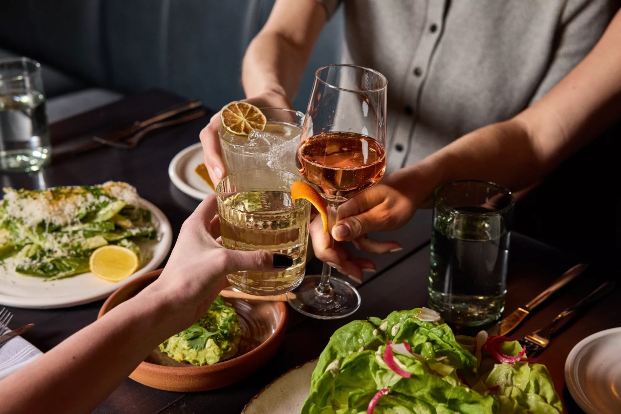 hands holding wine and cocktails