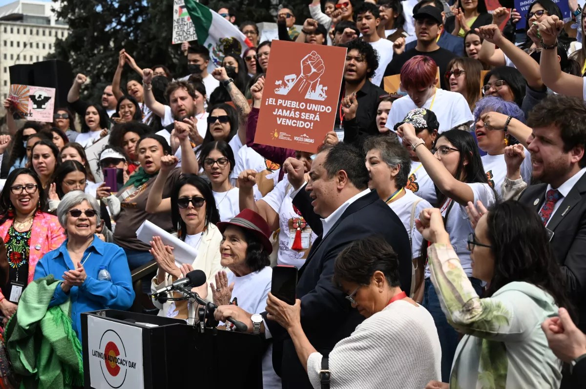 A crowd applauds Dolores Huerta's comments.