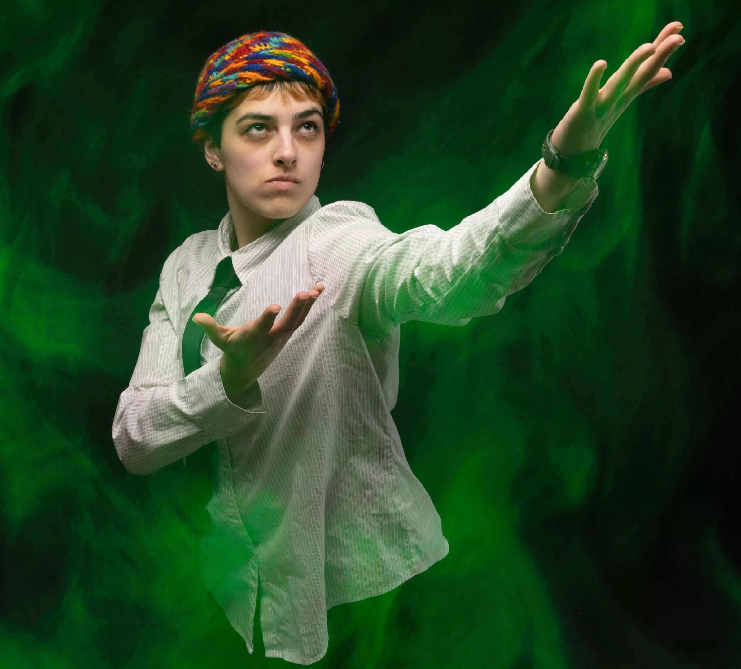 A person poses with green smoke around them.
