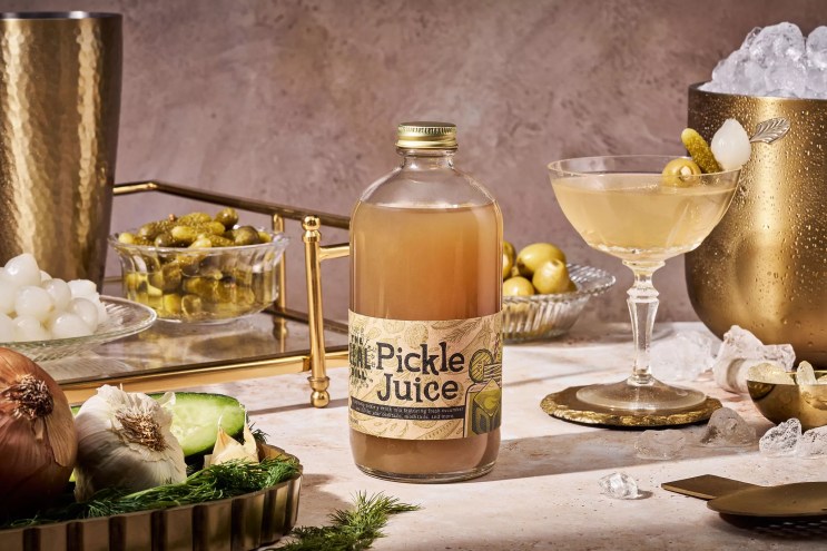 a bottle of pickle juice next to a martini