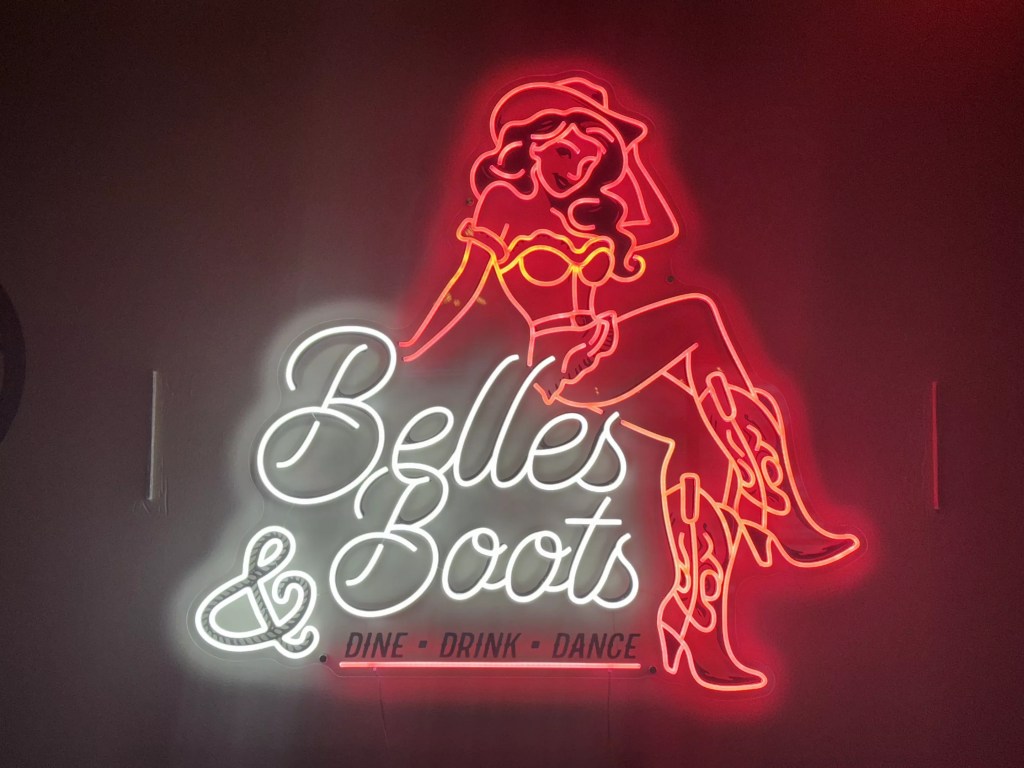 neon "belles & boots" sign