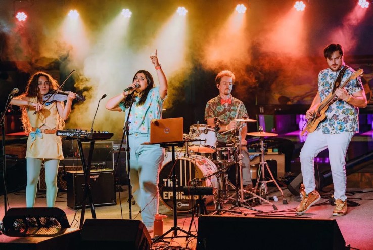 a band performing on stage with pretty lights