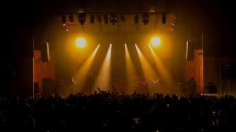 crowd in an indoor music venue with orange lights