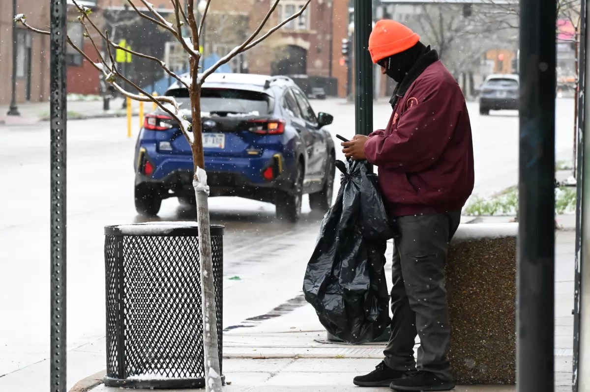 A man replaces a trash bin.
