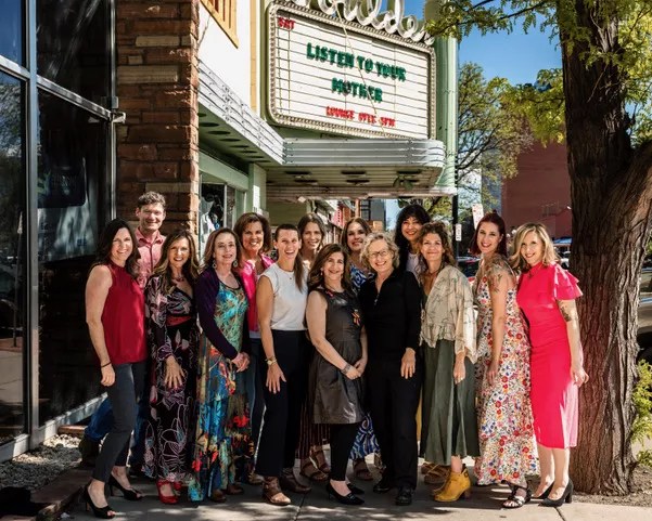 Women stand in front of a theater.
