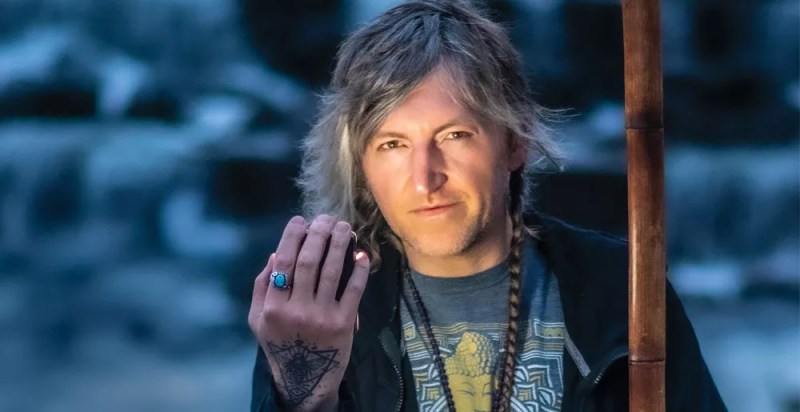 man with flow on face, hand up