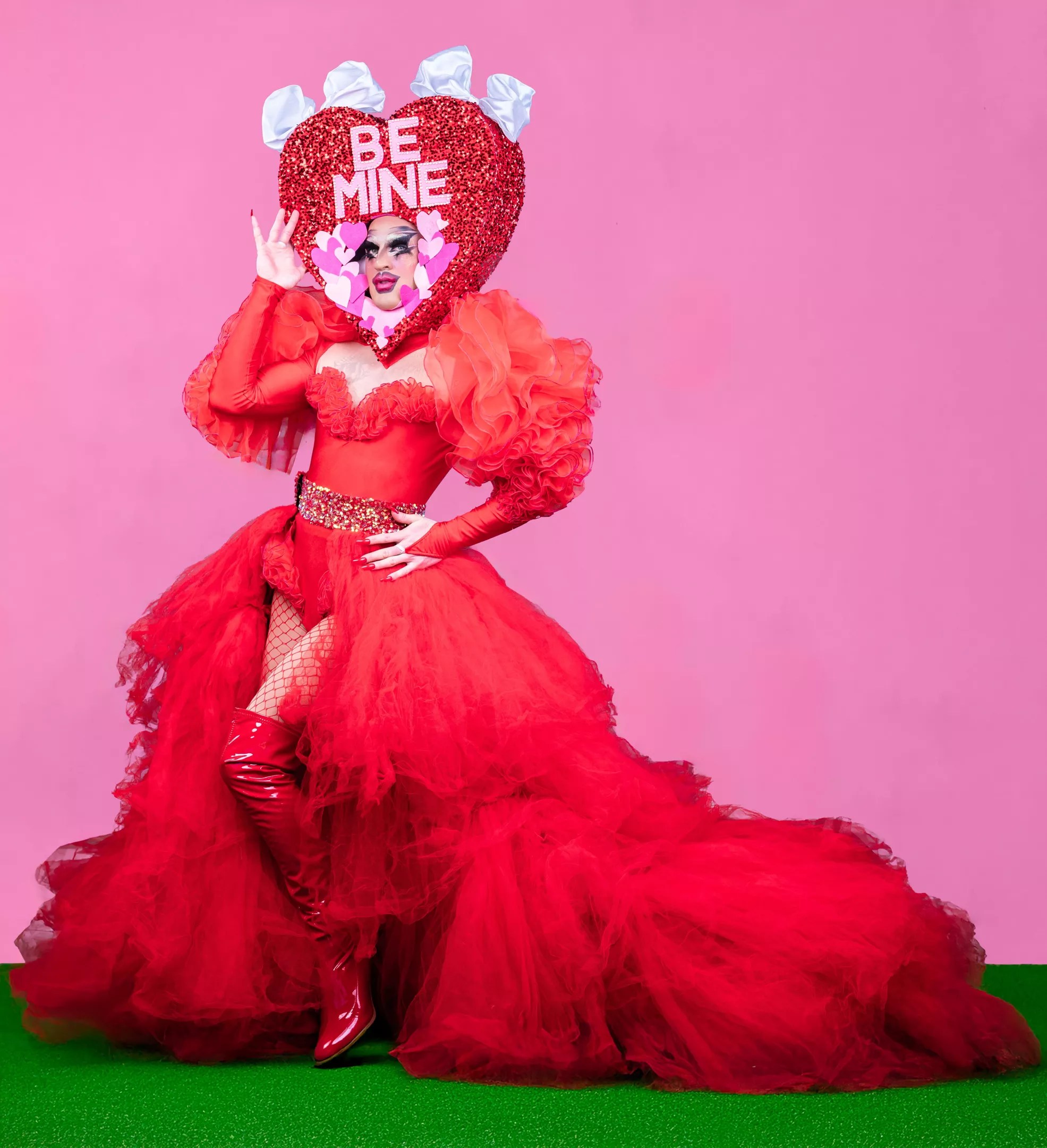 A drag performer strikes a pose in red.