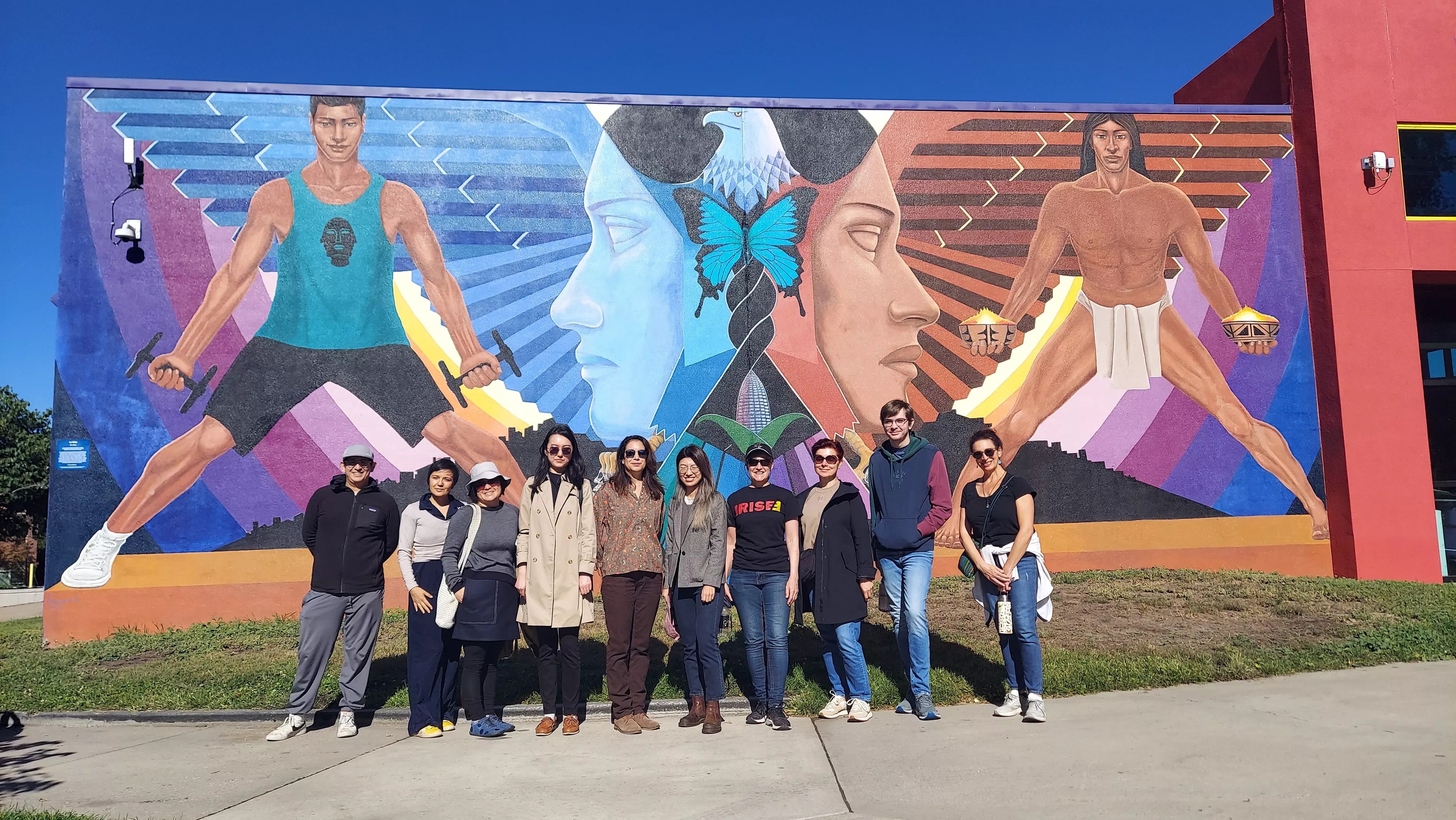 people standing by chicano mural