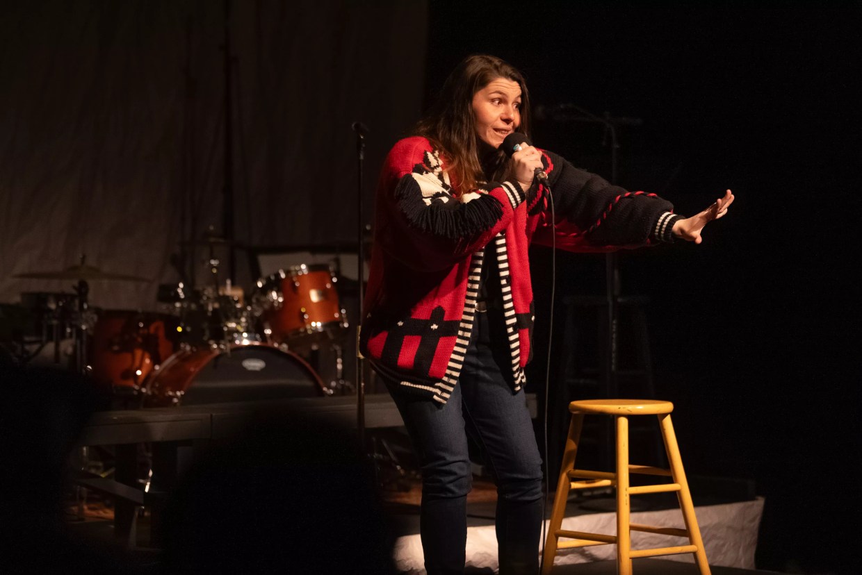 A woman talks into a microphone.