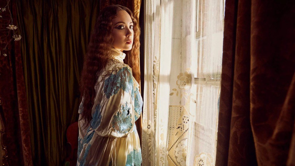 the singer Laufey by a window