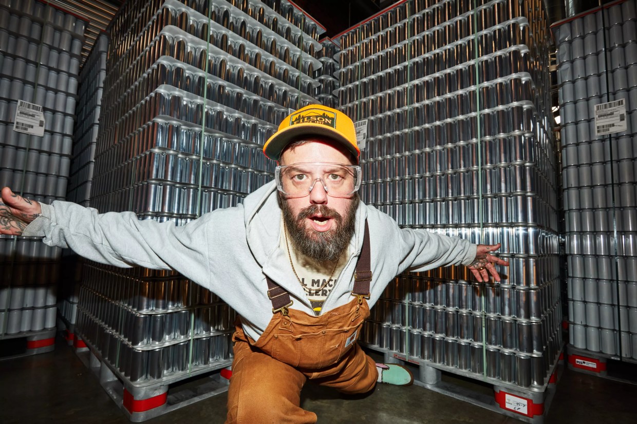 Jordan Childs posed in front of pallets of aluminum beer cans