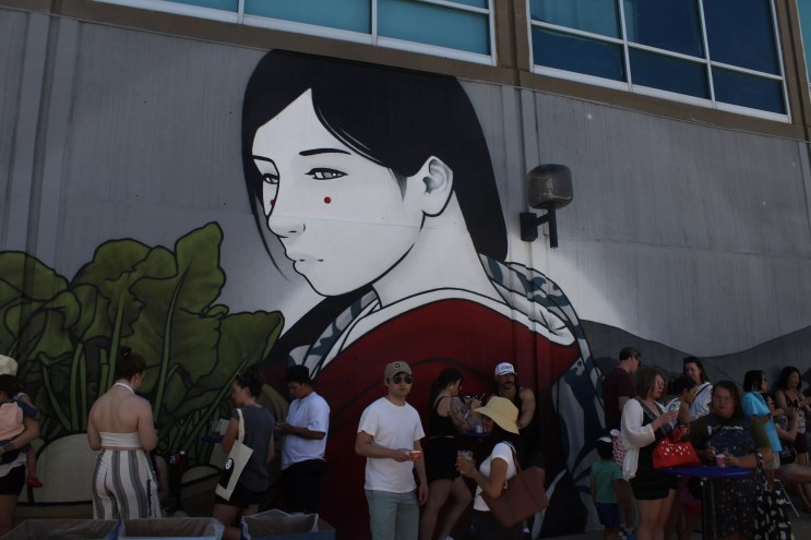 People stand by a mural