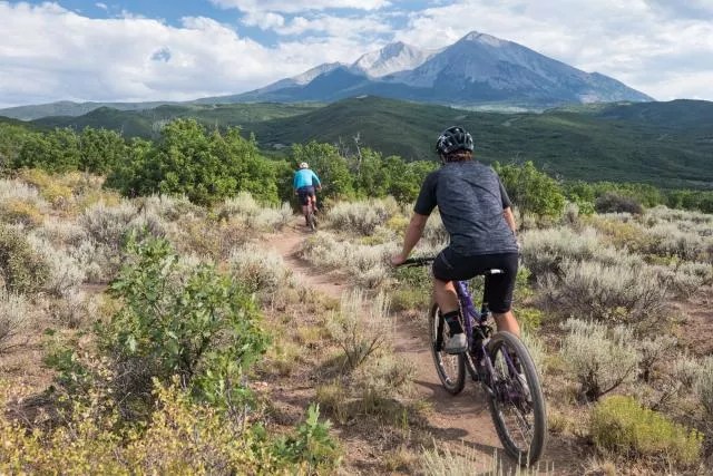 People riding mountain bikes on trail in Colorado