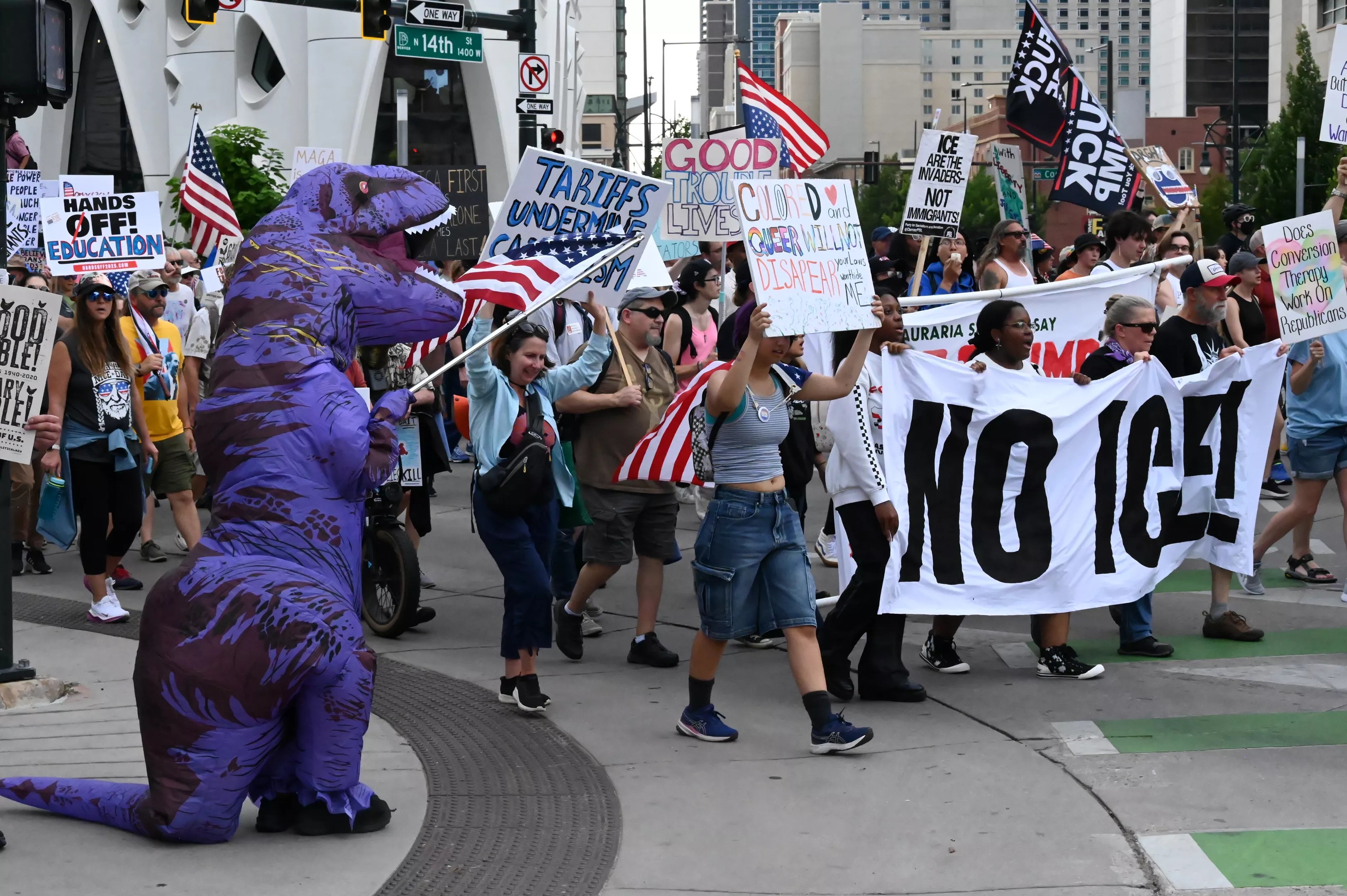 A trex waves the American flag during a march.