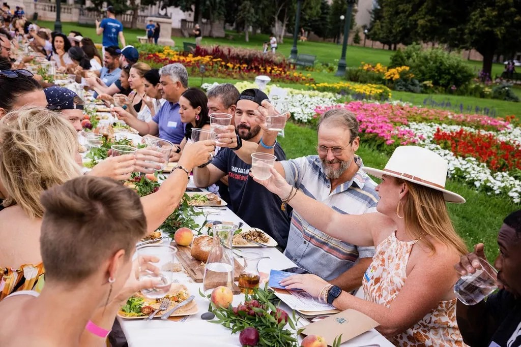 People sharing a toast during a Longer Tables event in Civic Center Park