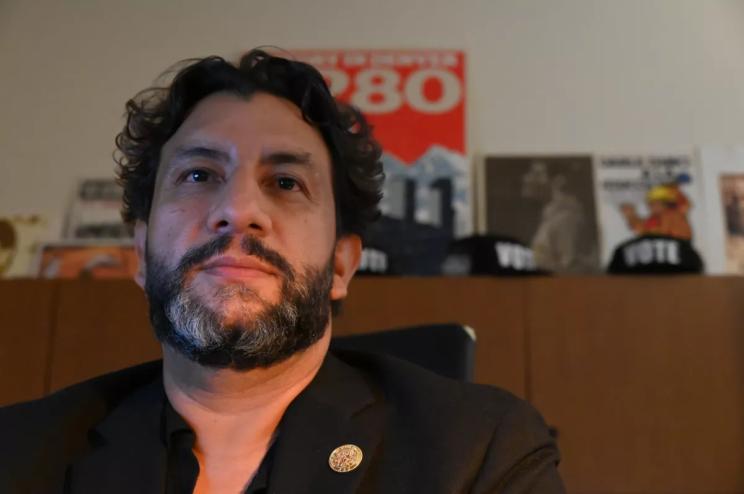 Paul López sits in his office.