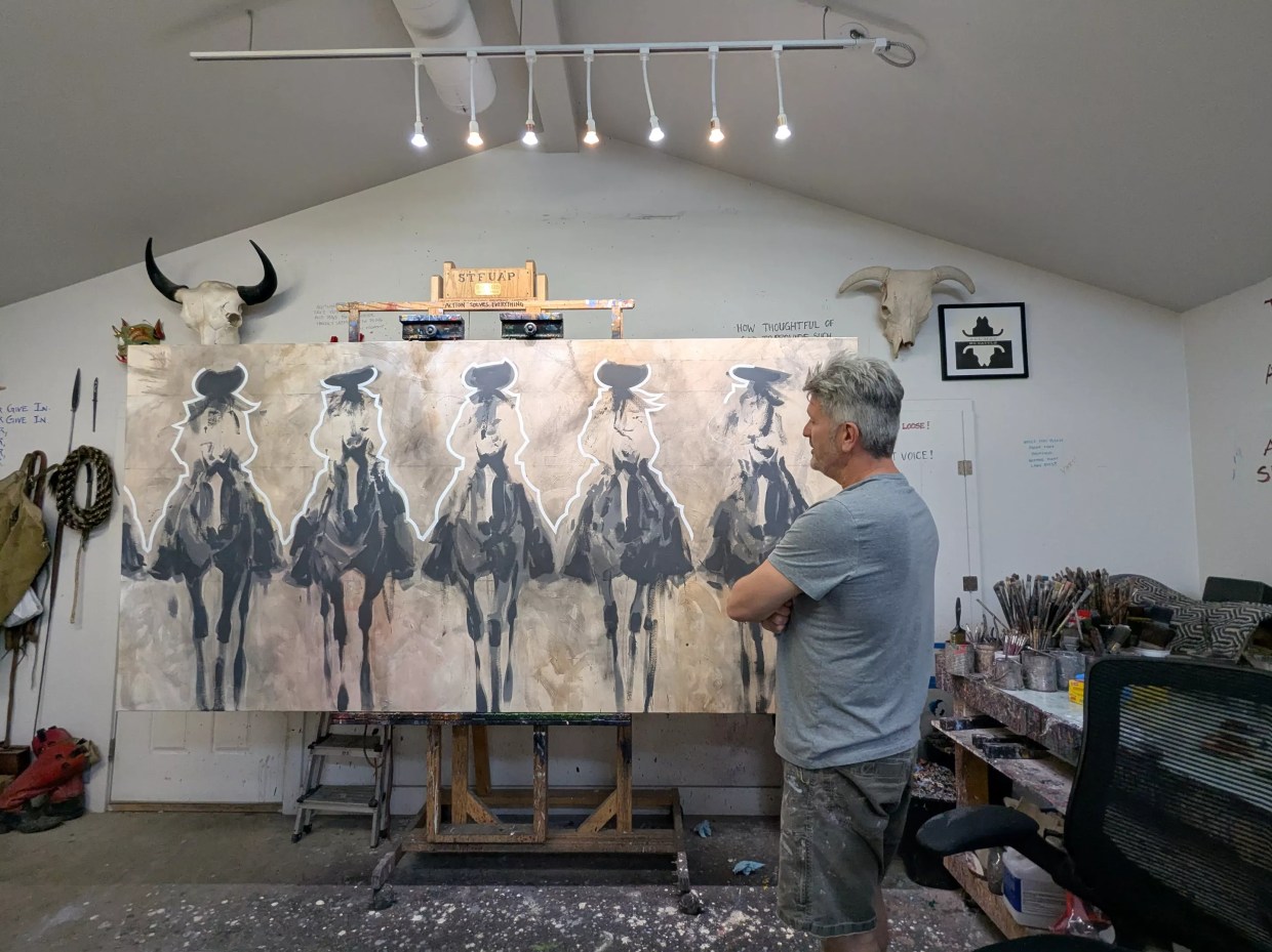 A man looks at his artwork