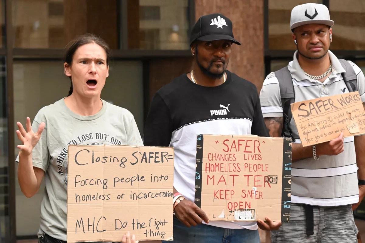 Activists hold up signs.