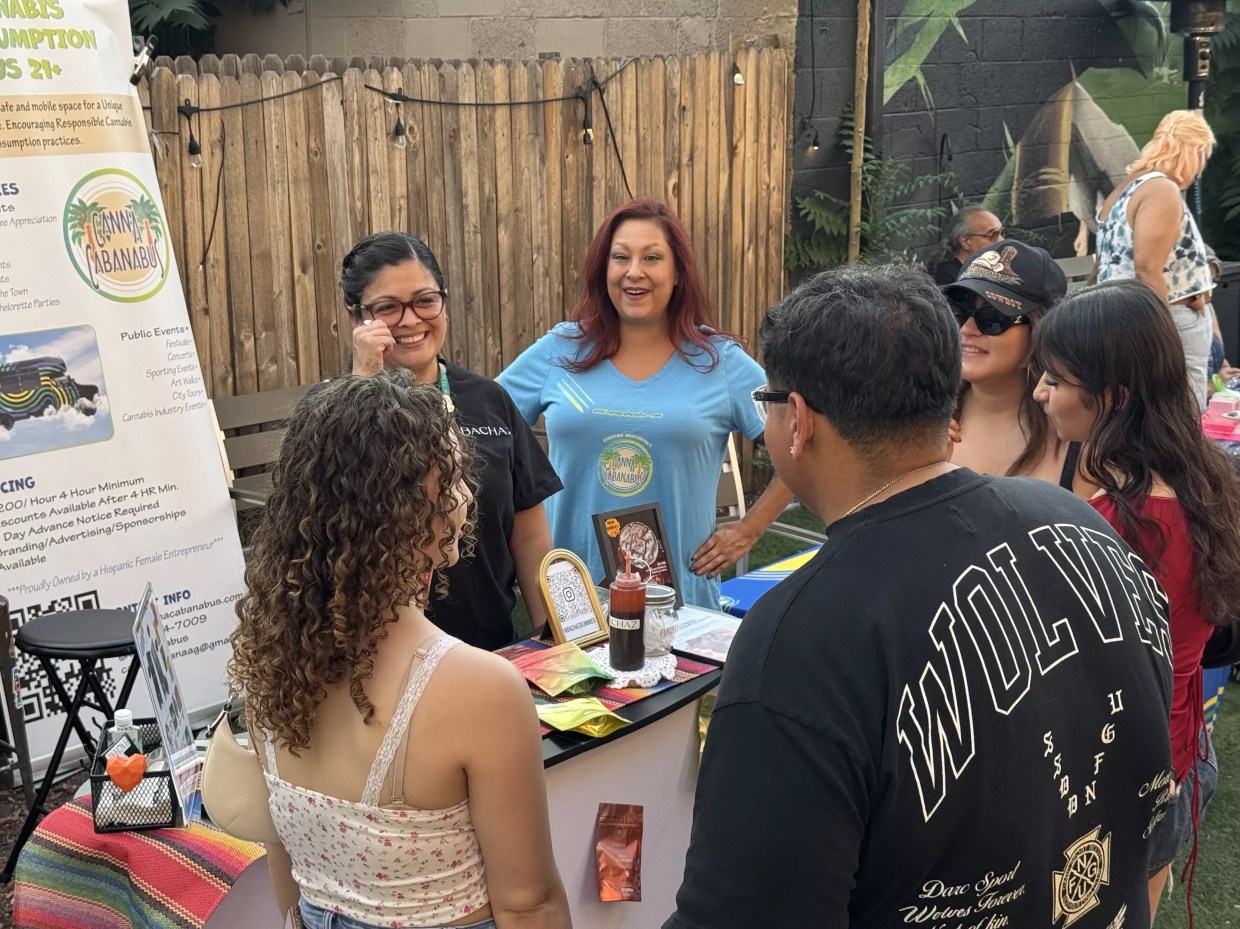 People gather around table in backyard