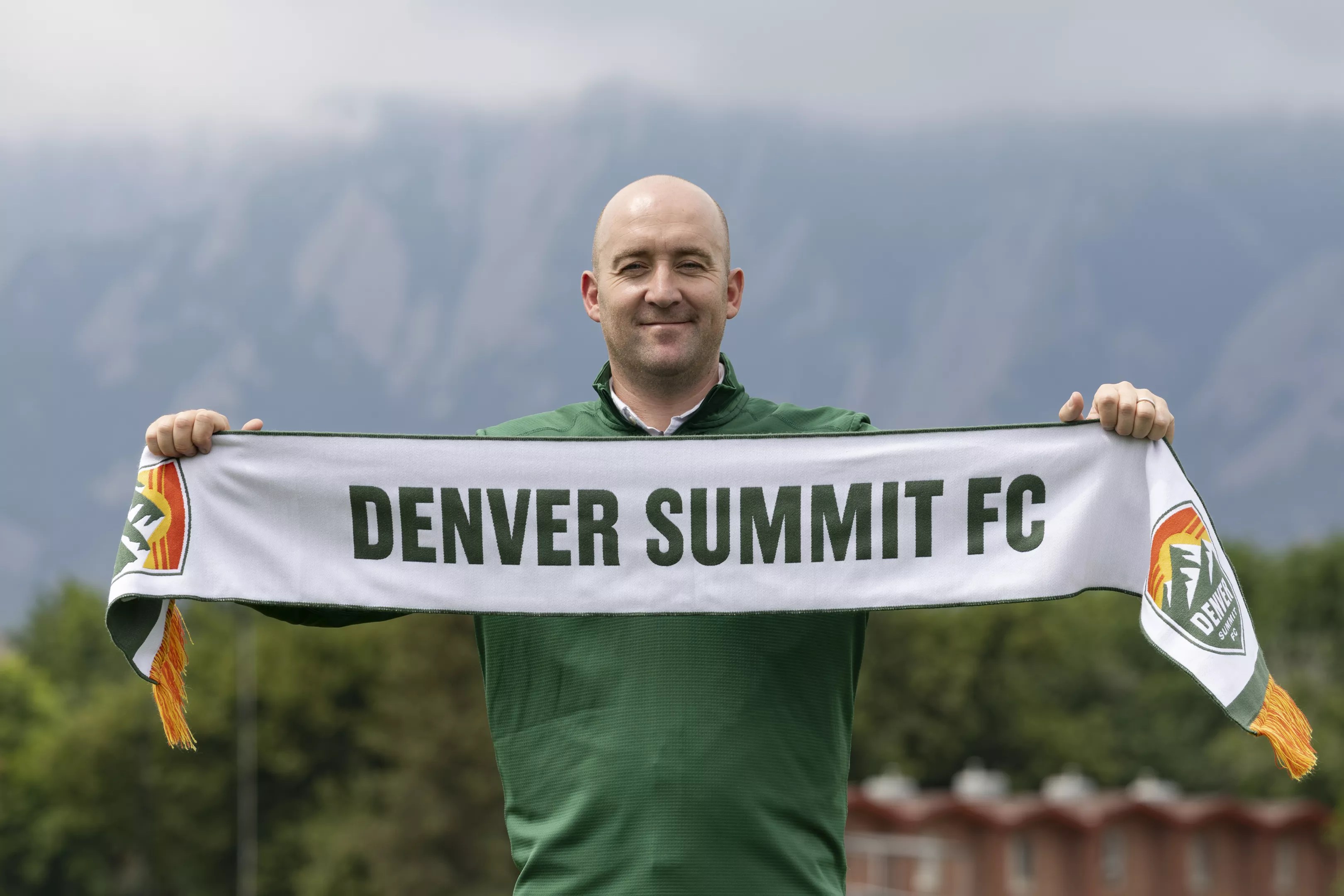 Man holds Denver Summit FC scarf