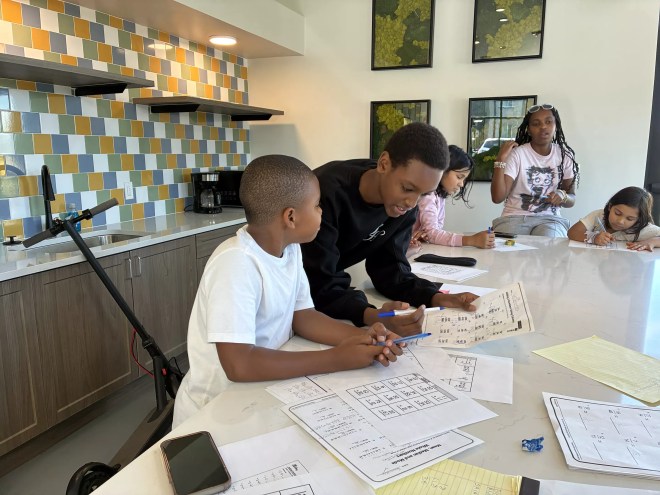 A teenager tutors a younger kid.