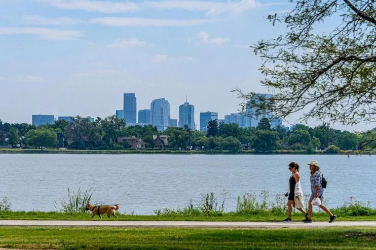 People walk near Sloan's Lake.