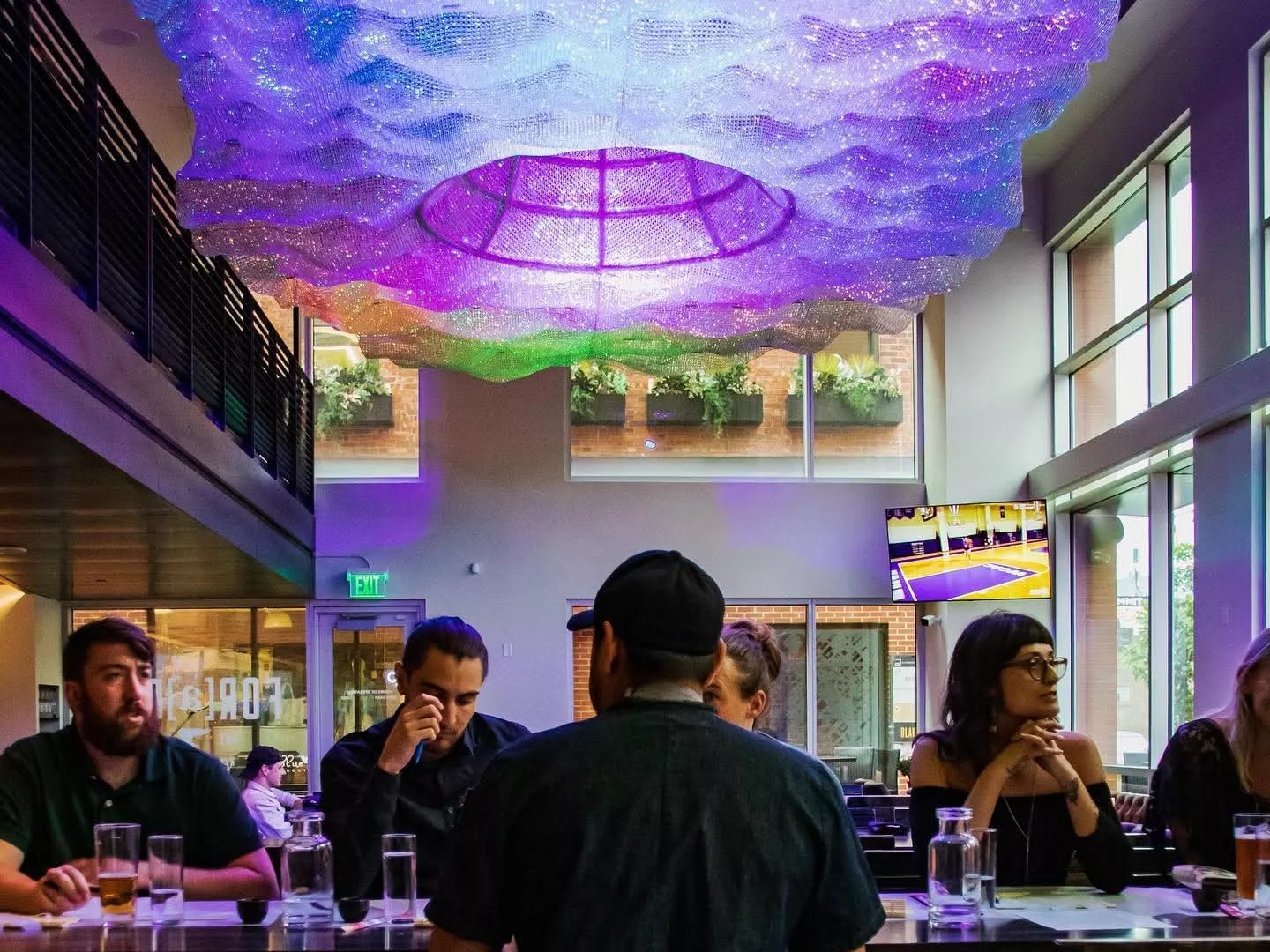people steated at a table under purple lighting
