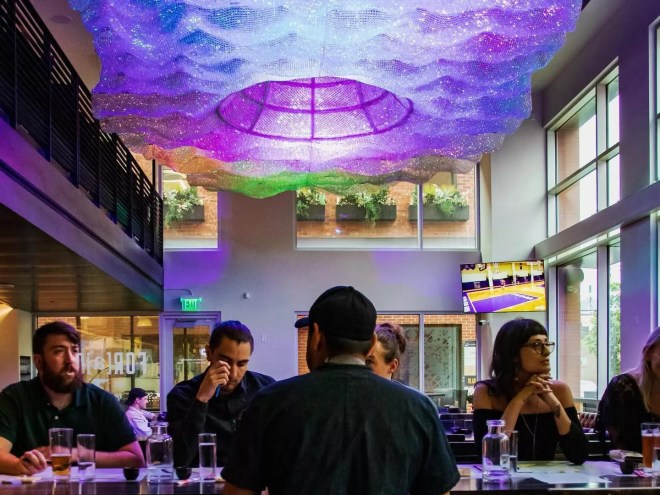 people steated at a table under purple lighting