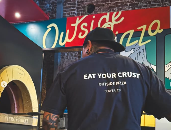 person staning in front of an "outside pizza" sign